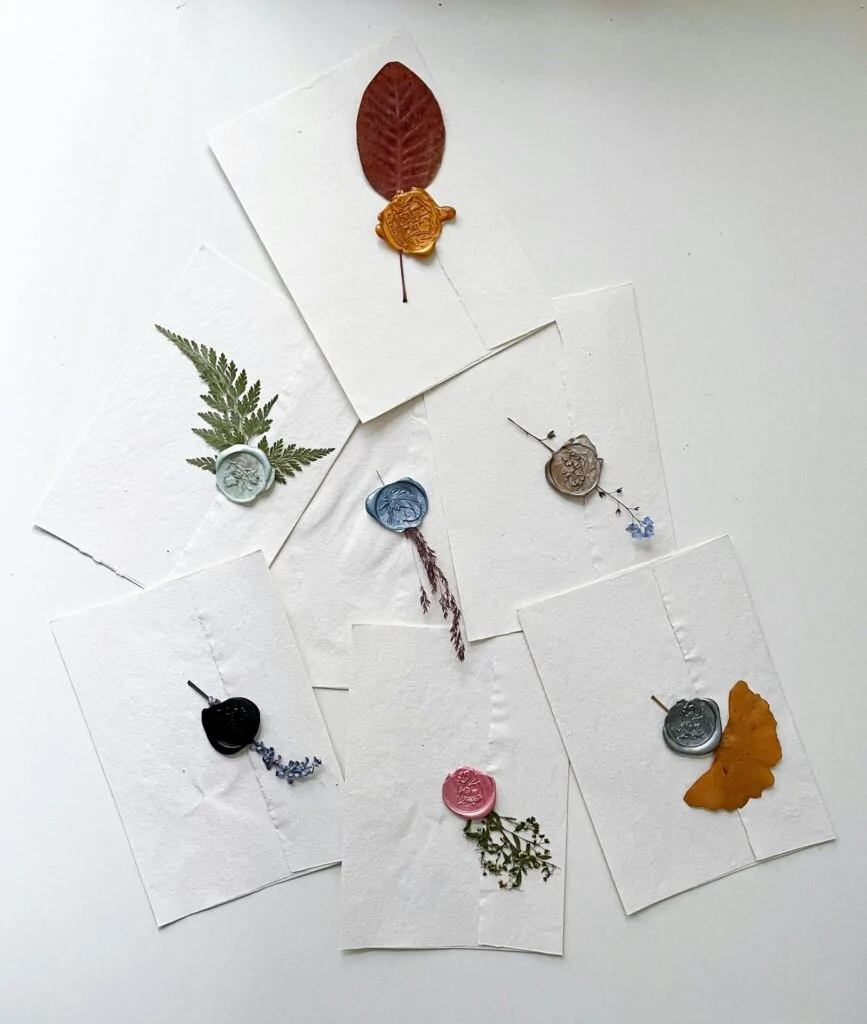 Carte, foglie d'autunno e sigilli colorati. Ogni busta un piccolo quadro — la corrispondenza come forma d'arte.